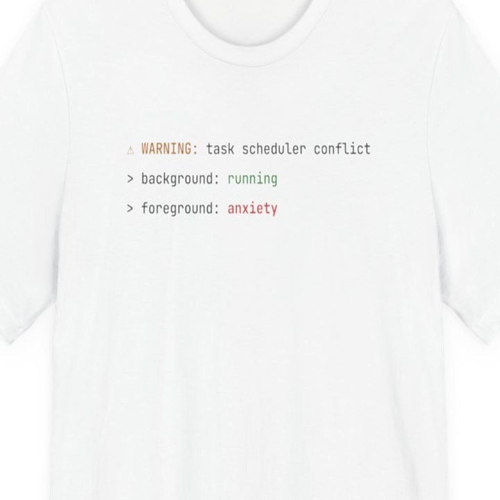 Black t-shirt with "Background Task, Foreground Anxiety" text in monospace amber font on dark background