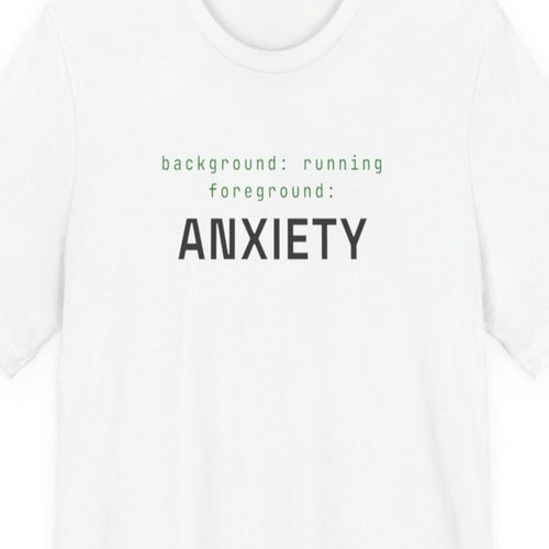 Black t-shirt with white text reading "Background Task, Foreground Anxiety" in monospace developer font